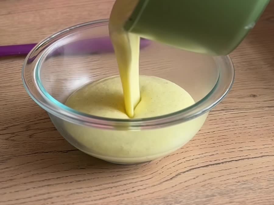 Vertiendo la crema pastelera caliente en un bowl de vidrio