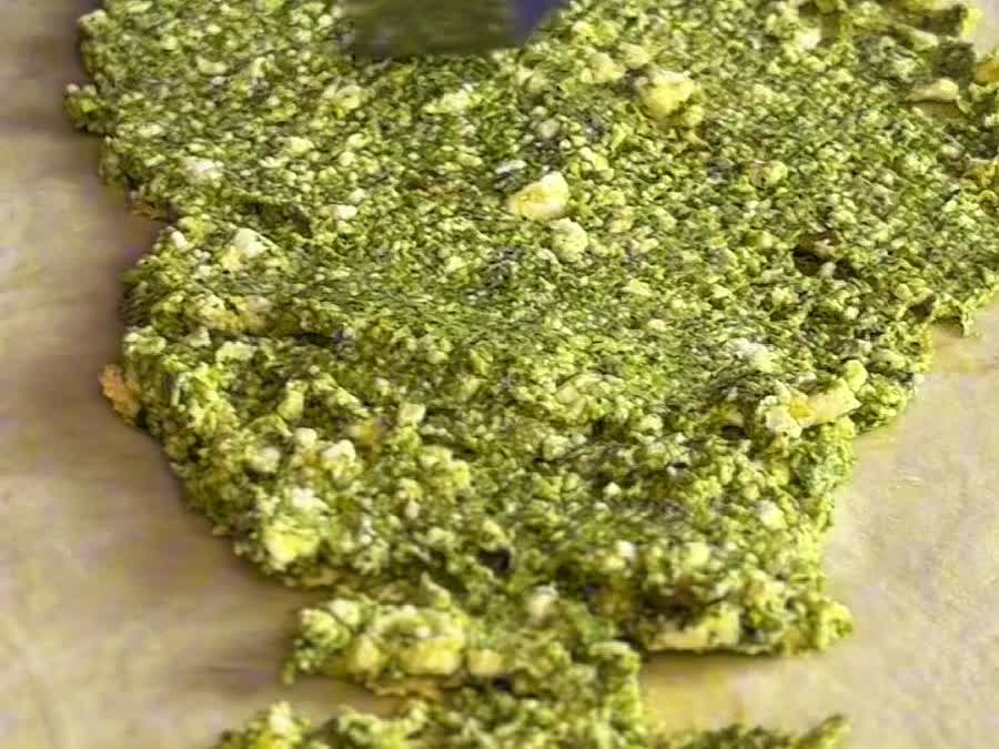 La masa estirada y cubierta con la mezcla de pesto