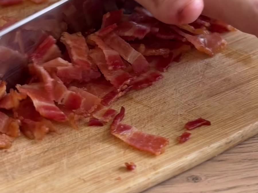 Tocino crocante picado sobre una tabla de madera