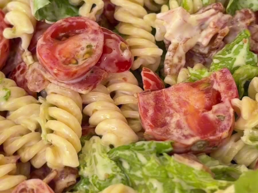 Primer plano de la ensalada caprese con pasta, tomates cherry y tocino