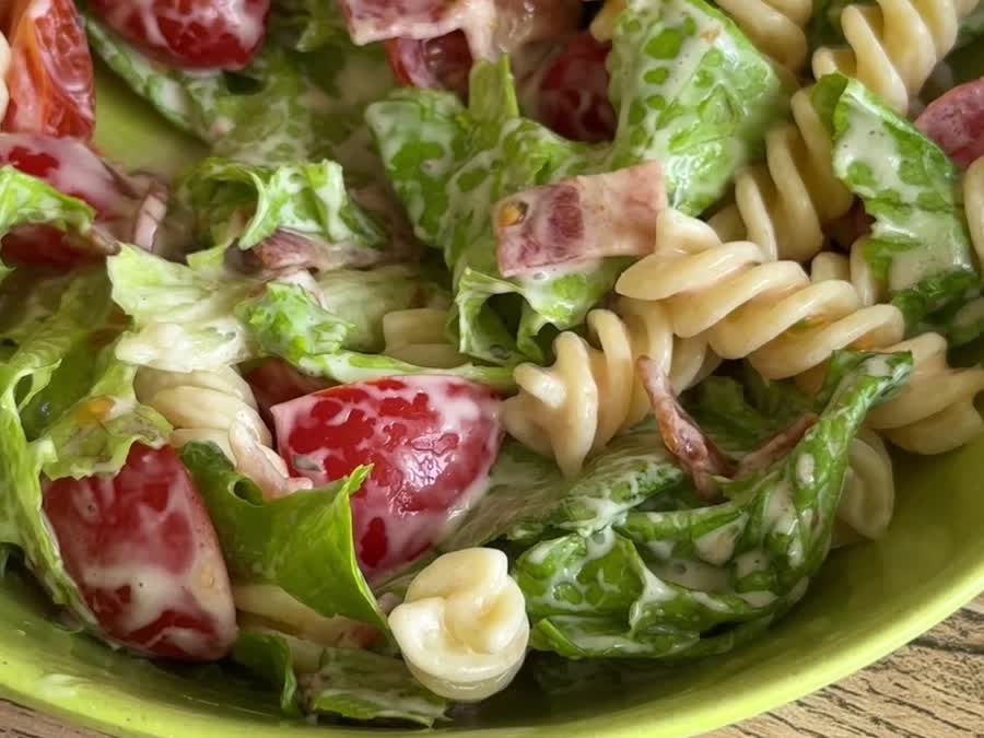 Ensalada caprese con pasta servida en un bowl verde