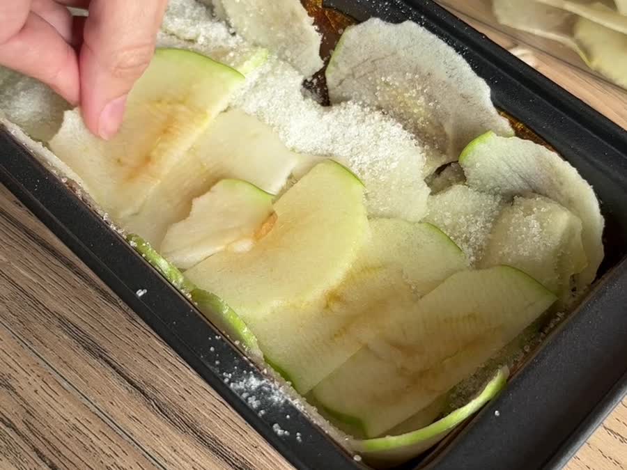 Acomodando las láminas de manzana con azúcar en el molde