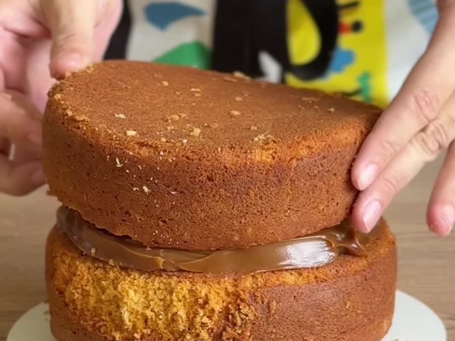 Los dos bizcochos de la torta de caramelo, rellenos con dulce de leche