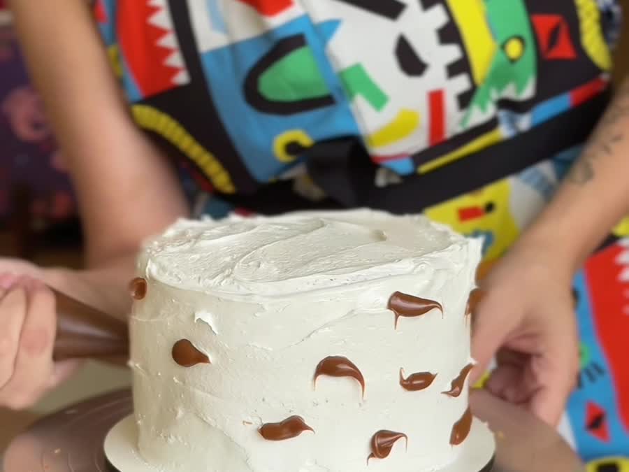 Torta cubierta de merengue suizo con puntos de caramelo antes de marmolear