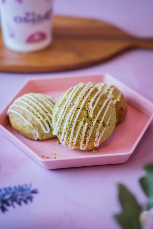 Galletas de pistacho con hilos de chocolate blanco sobre un plato rosado