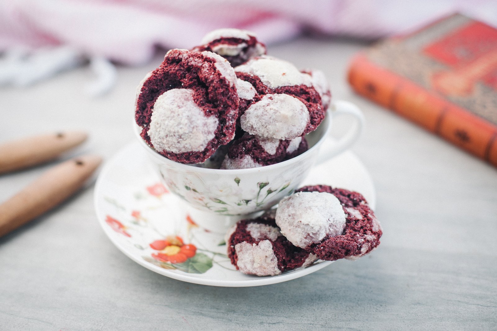 Galletas red velvet agrietadas con azúcar glas, dentro de una taza de porcelana