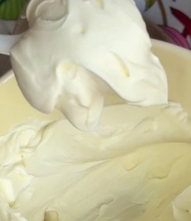 Mascarpone casero terminado, cremoso y liso, en un bowl blanco