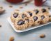 Galletas de mora y almendras sobre una bandeja blanca, con almendras alrededor