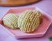 Galletas de pistacho con hilos de chocolate blanco sobre un plato rosado