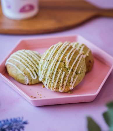 Galletas de pistacho con hilos de chocolate blanco sobre un plato rosado