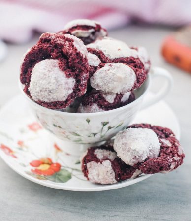 Galletas red velvet agrietadas con azúcar glas, dentro de una taza de porcelana
